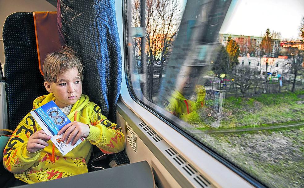 Oleg, un niño ucraniano contempla el paisaje desde la ventanilla del tren en el que viaja ya en tierras de Polonia. 