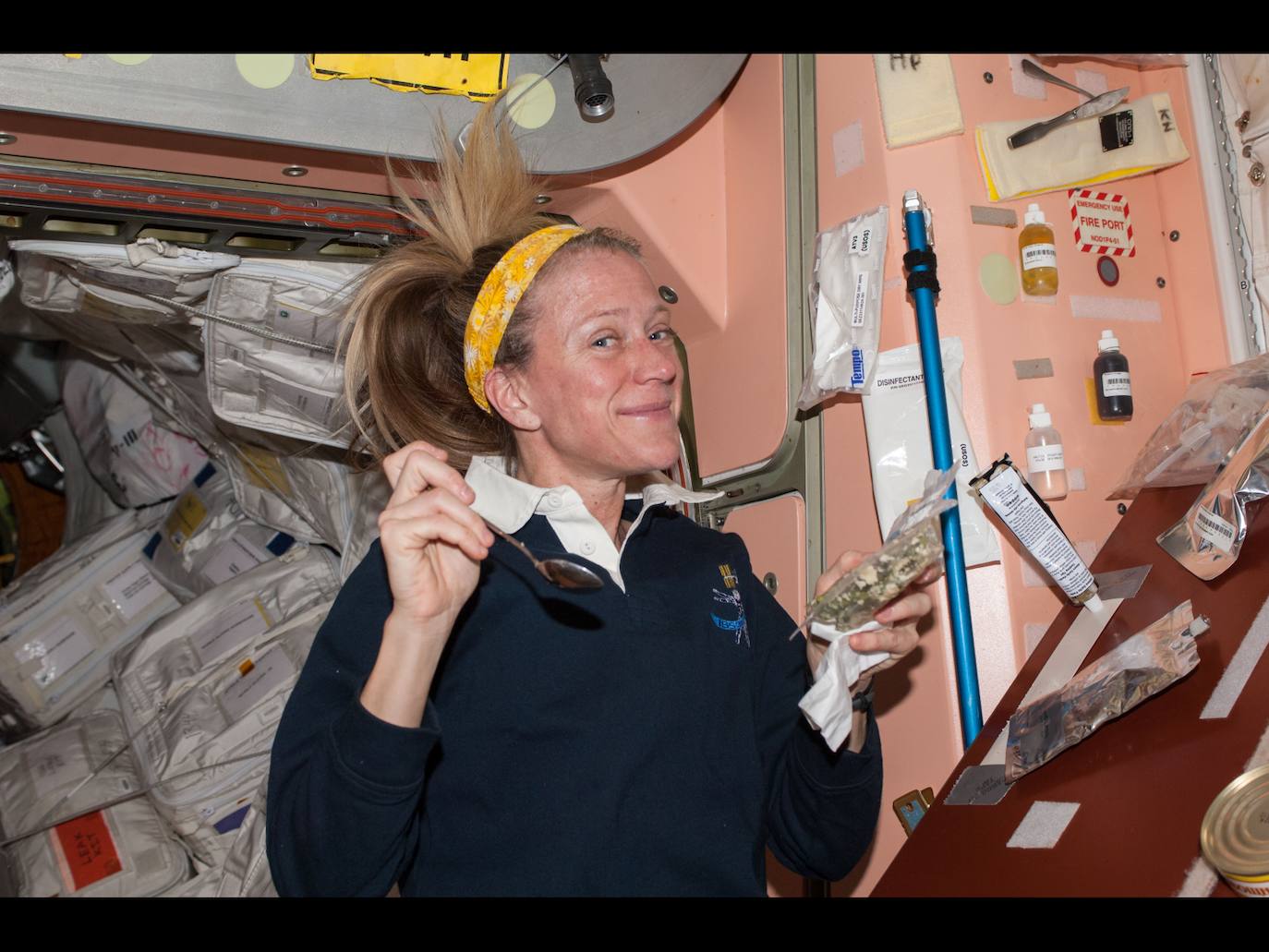 La astronauta de la NASA Karen Nyberg, ingeniera de vuelo de la Expedición 37 de la Estación Espacial Internaciona, en 2013, se prepara para comer su almuerzo en el nodo Unity.