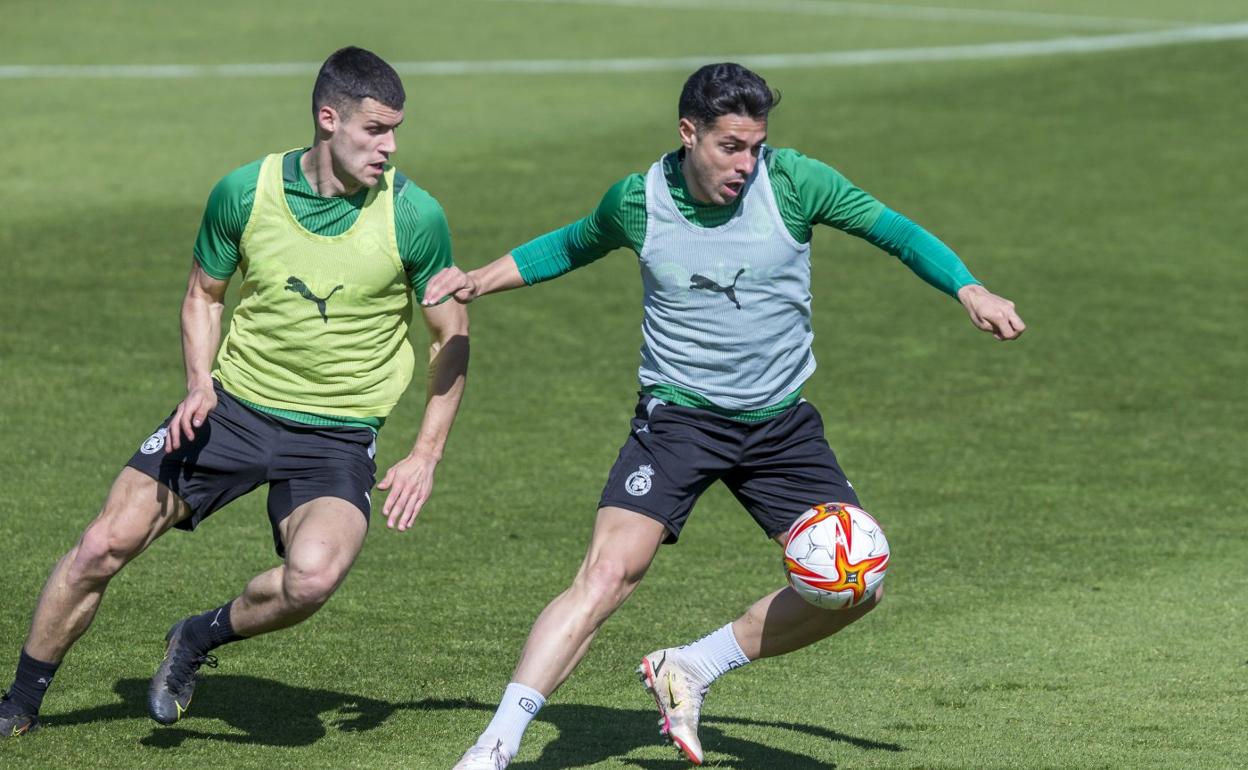 Mantilla trata de robar el balón a Álvaro Bustos durante un entrenamiento esta semana en La Albericia. 