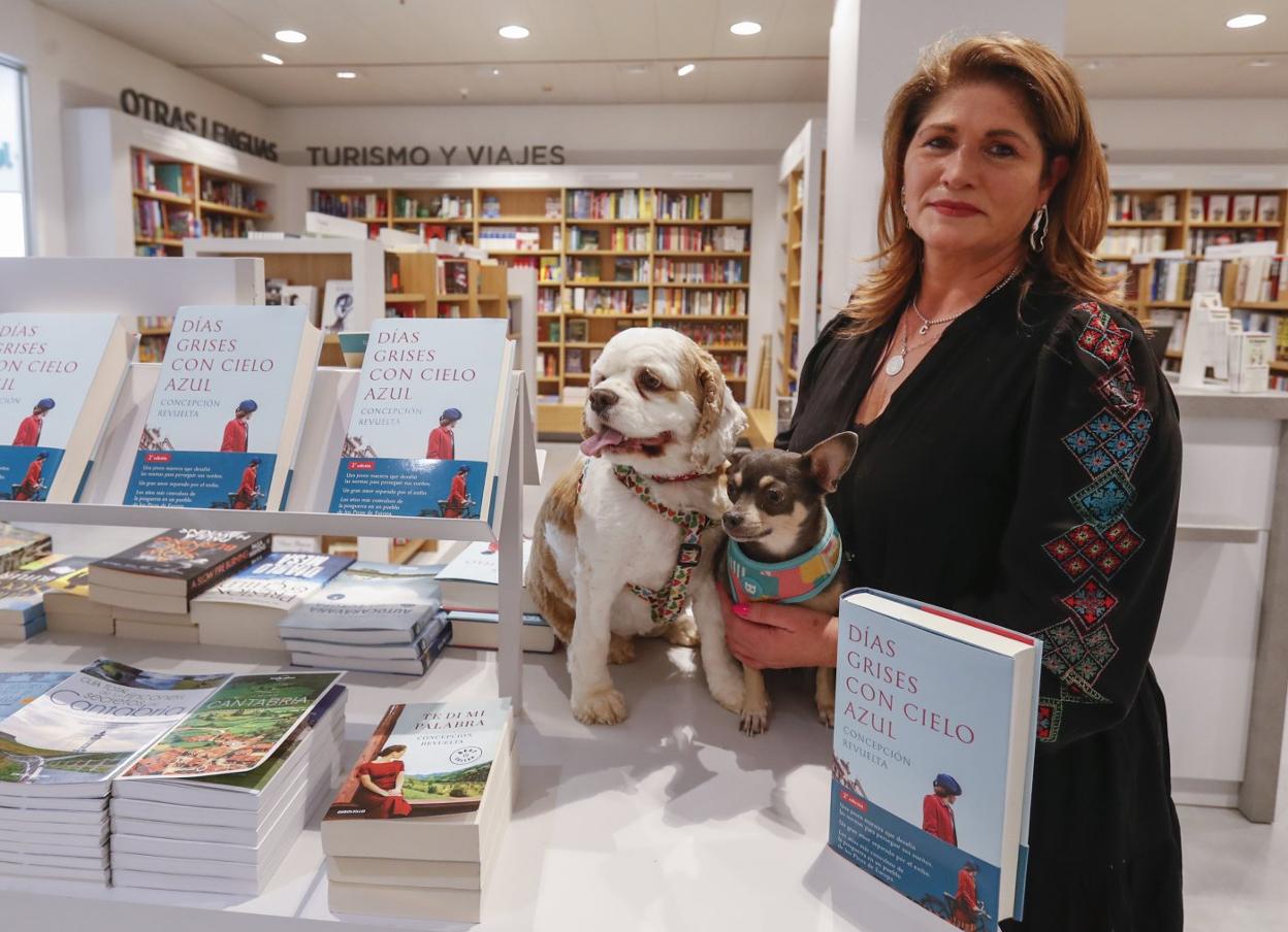 La escritora Conchi Revuelta posa con Dana, Penny y ejemplares de su última obra en la librería de El Corte Inglés. 