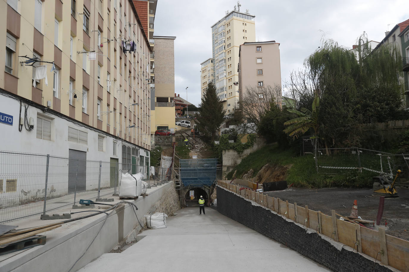 Imagen. En Las Canteras. Una rampa hasta la entrada. A un lado se conserva el muro original y se completa hasta la cota de los edificios. Al otro, un muro de piedra enrejada (gaviones). Una escalera conectará con Barrio Camino.