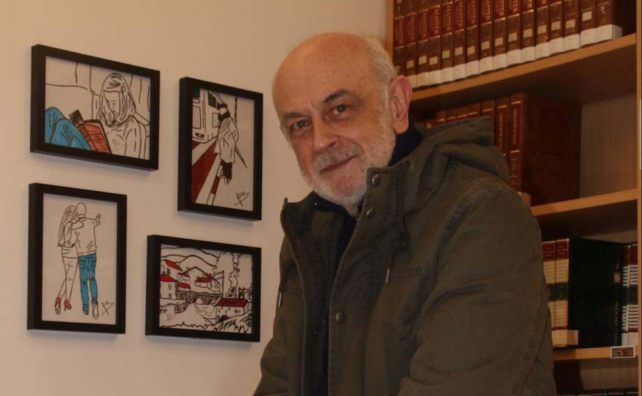 El escritor en la biblioteca de La Cavada junto a unos dibujos creados por él 