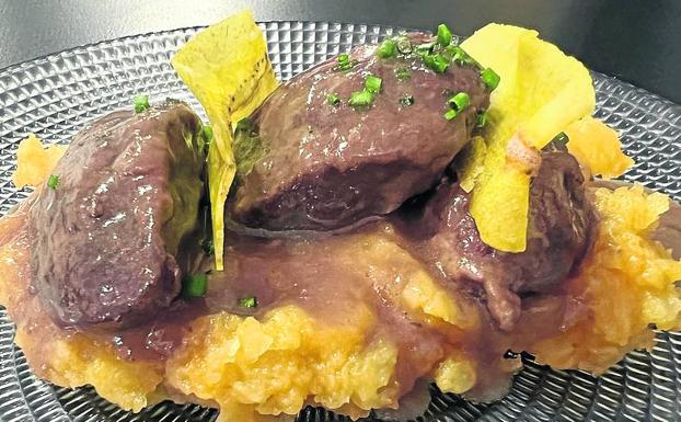 Carrilleras al vino tinto con chips de plátano. 