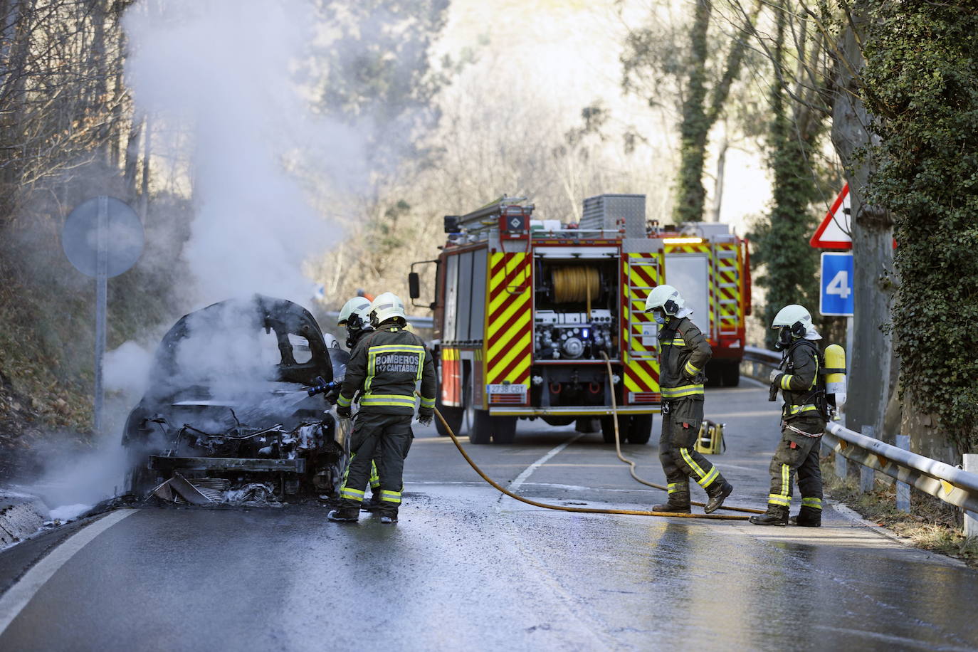 Los bomberos del 112 extinguen un incendio en un coche de combustible con agua y espuma. Si fuera eléctrico, lo harían con una manta ignífuga.