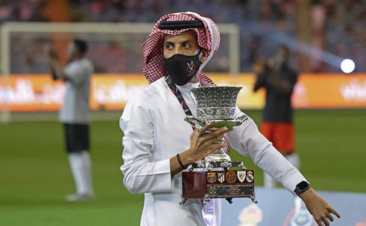 Un miembro de la organización de la Supercopa de España 2022 en Arabia Saudí, con el trofeo. 