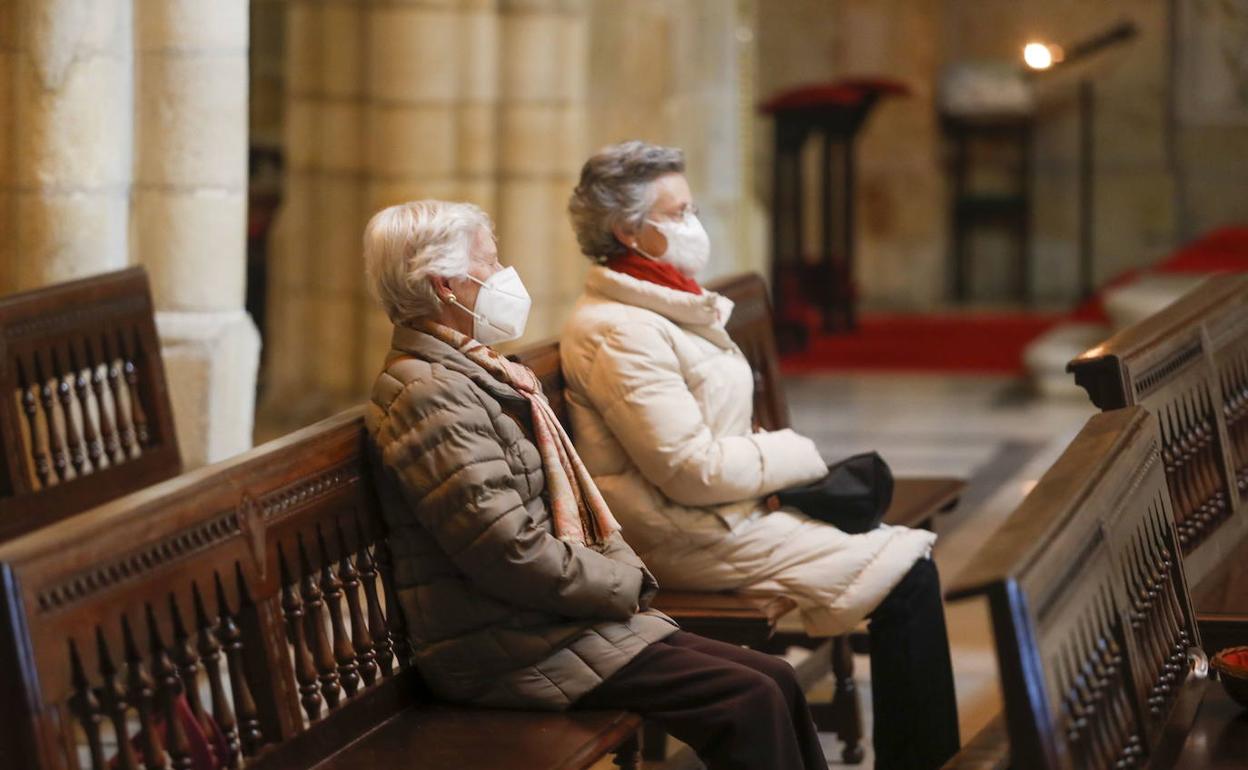 Dos mujeres asisten a una eucaristía en la catedral de Santander. 