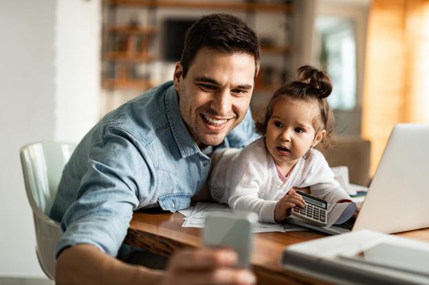 Padre junto a su hija, con cara extrañada frente al teléfono.