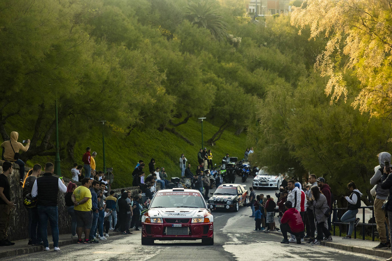 La caravana de vehículos, encabezada por un Mitsubishi Evo, en el aparcamiento de la Playa de El Camello.