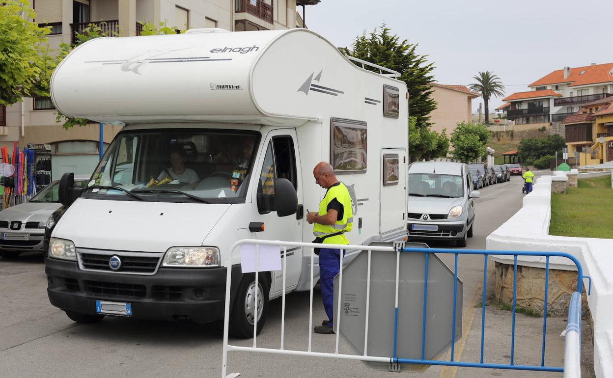 Una autocaravana en la entrada al aparcamiento situado junto a la playa de Comillas 