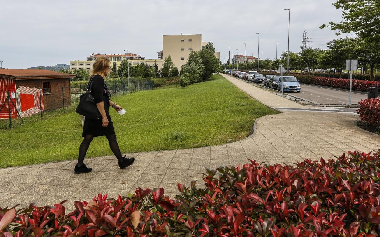 Una vecina camina por la acera, frente al solar donde Industria contempla la nueva sede del Parque Tecnológico, ayer, en Torrelavega. 