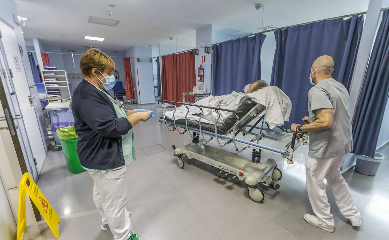 Un celador traslada en camilla a una paciente que acaba de ingresar en el servicio de Urgencias de Valdecilla. 
