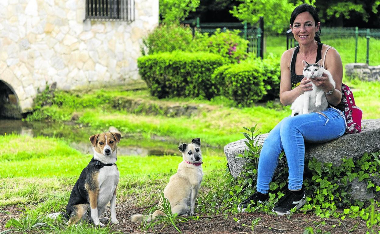 La presidenta de Aspacán, Guadalupe Vega, se retrata con Asia y Beldur, sobre el césped, y Lola, en su regazo. 