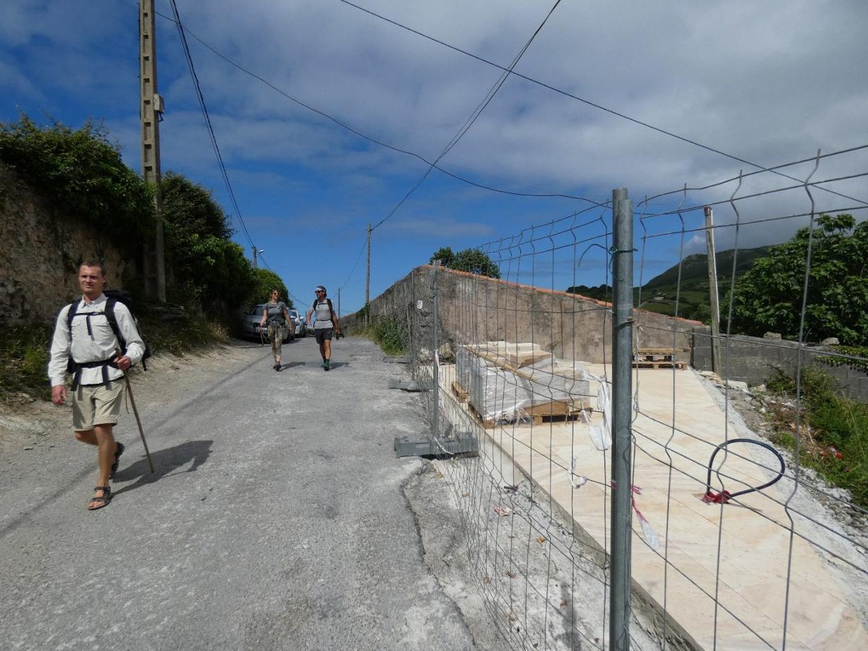 Unos peregrinos pasan junto a la zona donde se realizará el área de descanso dedicada a ellos.