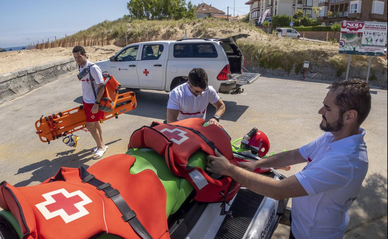 Los socorristas de Cruz Roja trasladan el material al módulo en la playa del Ris, en Noja. Ya trabajan este fin de semana.