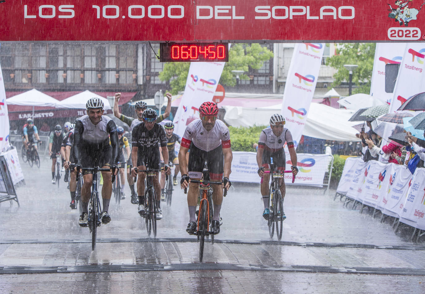 Los ciclistas llegan a la meta en plena tormenta.