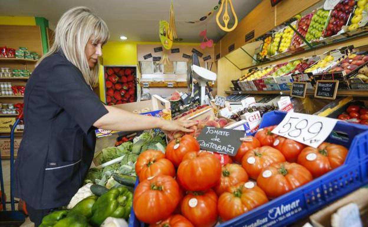 Nuria, propietaria de la frutería que lleva su nombre, en Torrelavega, coloca las frutas y verduras,