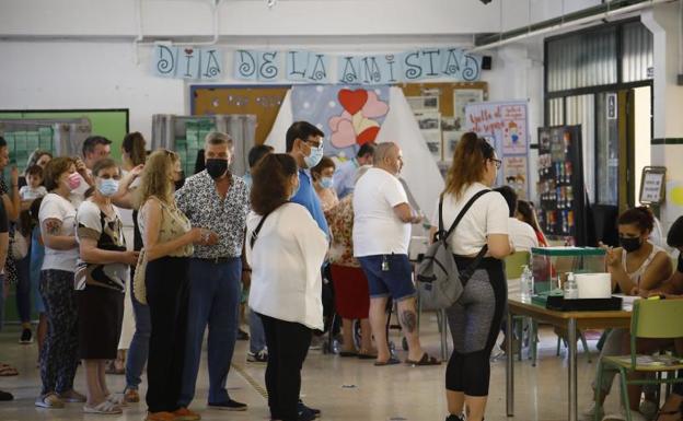 Colas de personas esperan para introducir en la urna su papeleta de voto en un colegio de Córdoba.