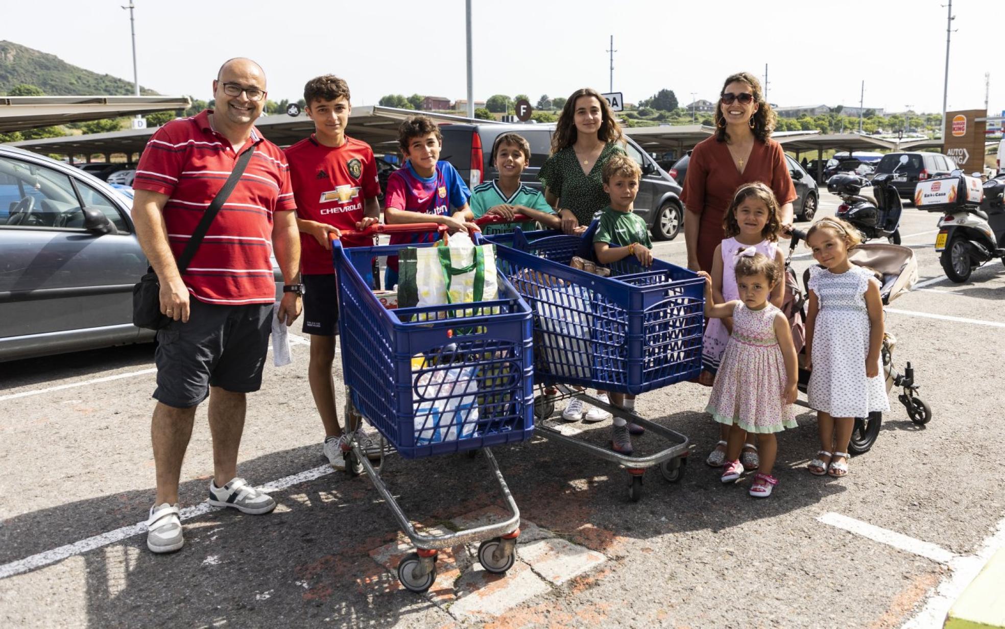 Esteban Campelo, Santiago (14 años), Pablo (12), Esteban (10), Inmaculada (16), David (8), Ana (6), Belén (2), Esperanza (4), José (8 meses) y Teresa Martínez, en el Carrefour de El Alisal después de hacer la compra.