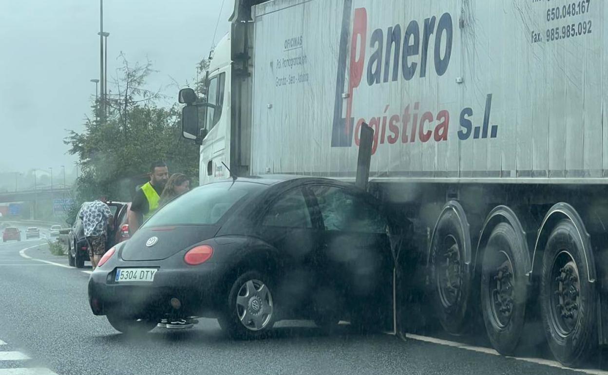 El coche, modelo New Beatle, se ha quedado empotrado en los bajos del camión. 