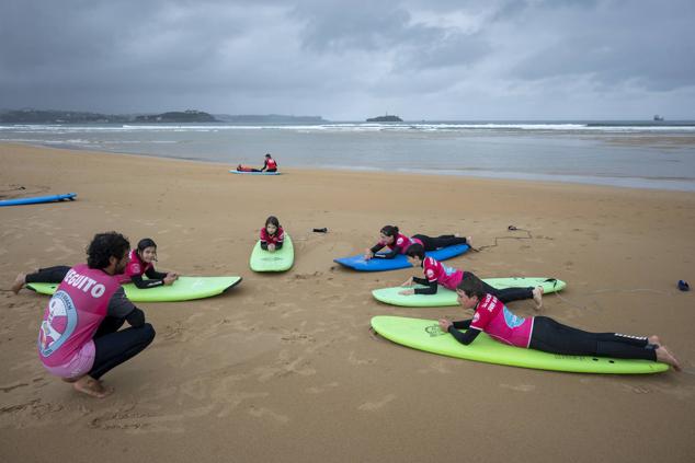 Tumbados sobre las tablas, el siguiente paso es ponerse de rodillas.