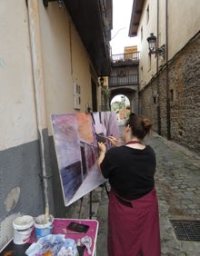 Imagen secundaria 2 - Los dos primeros clasificados junto a sus obras, y una artista pintando el arco de la Blanca durante el certamen 