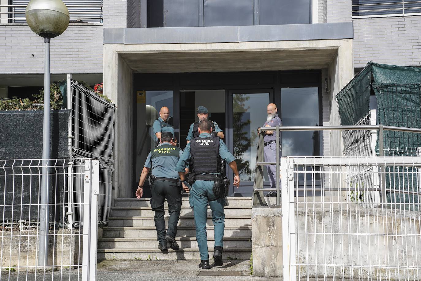 Agentes de la Guardia Civil en el instante previo al acceso a uno de los bloques de la urbanización.