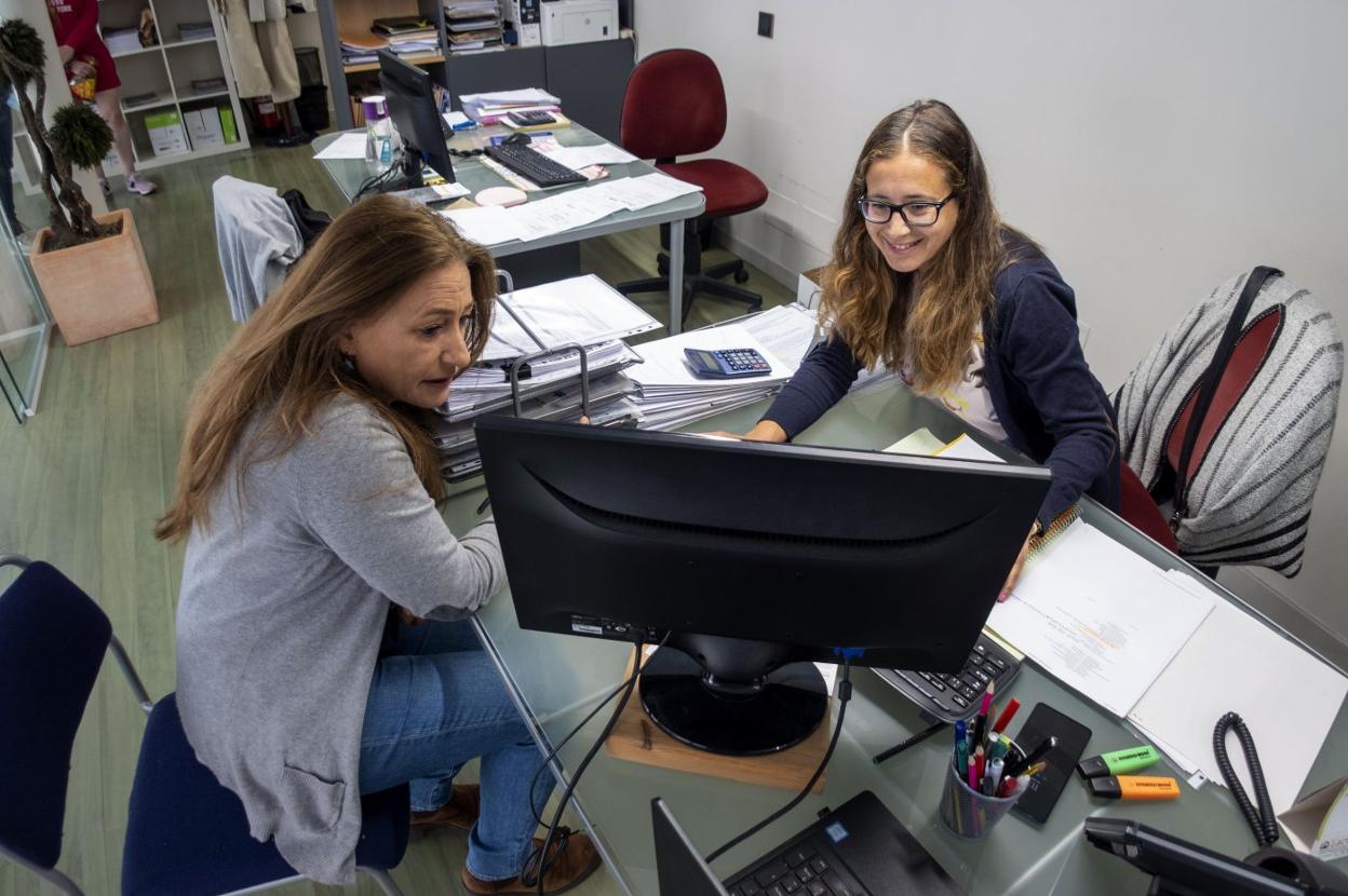 Planes de vacaciones. Consulta de los datos de un viaje en la oficina de Viajes Altamira, en Santander.