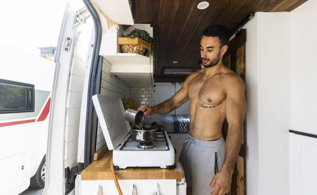 Sergio Martínez, ante la cocina de su furgoneta preparada por él y su pareja.