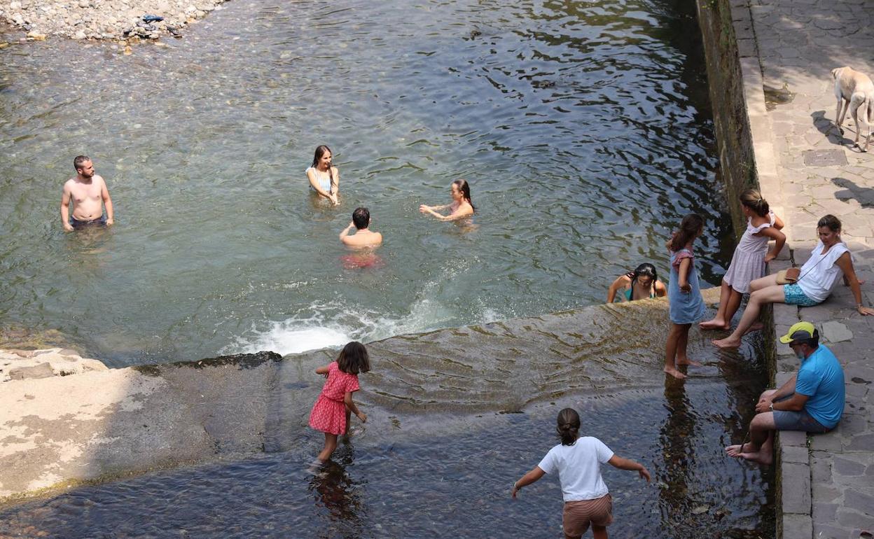 Bañistas se refrescan en el río Quiviesa a su paso por Potes. Liébana registró 38,9º en Tama. 