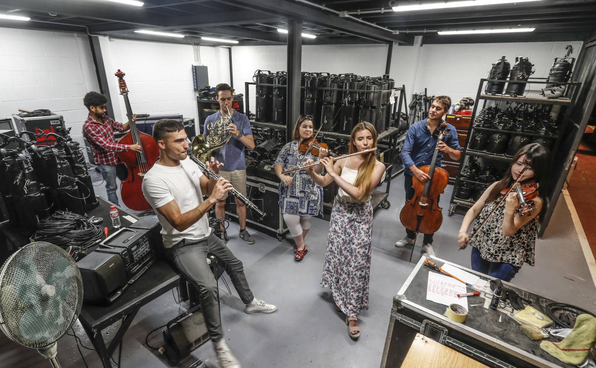 Andrés Arroyo, Pablo Balaguer, Máté Harangozó, Anna Csaba, Victoria Creighton, Milan Drake y Reika Sato posan con sus instrumentos en uno de los almacenes del Palacio de Festivales.