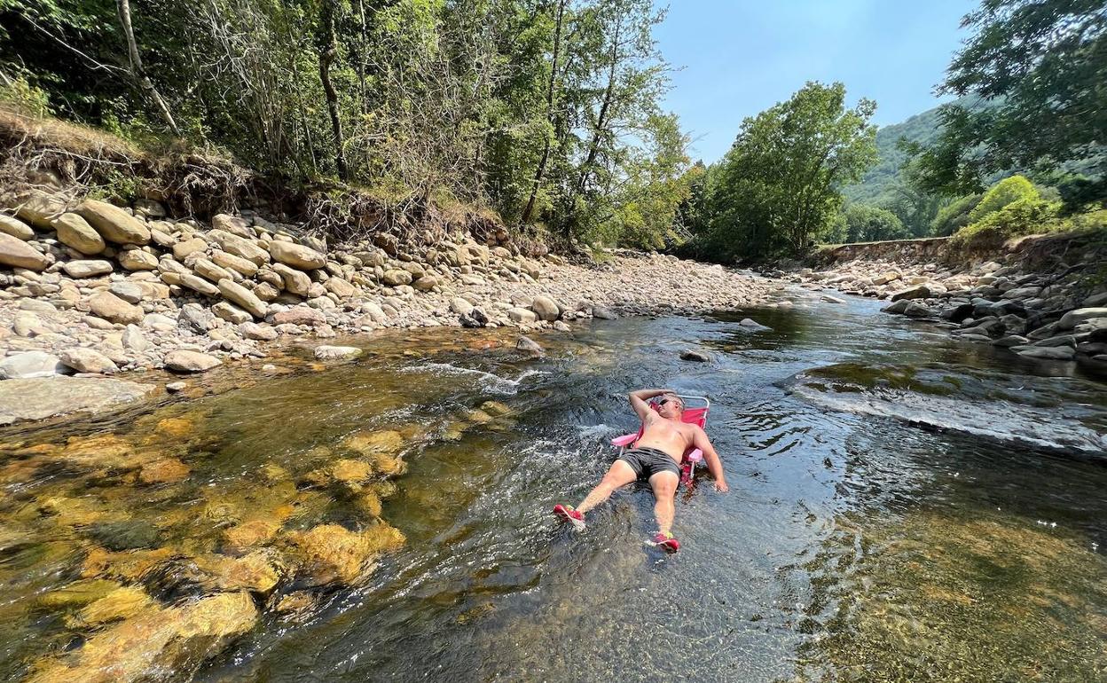 Un bañista se refresca en el río Saja en Cabuérniga