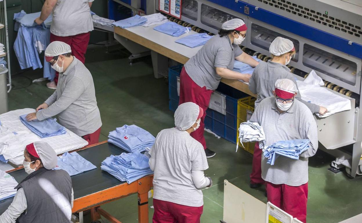 Imagen de archivo de trabajadores de Amica doblando ropa de hospital en sus instalaciones. 