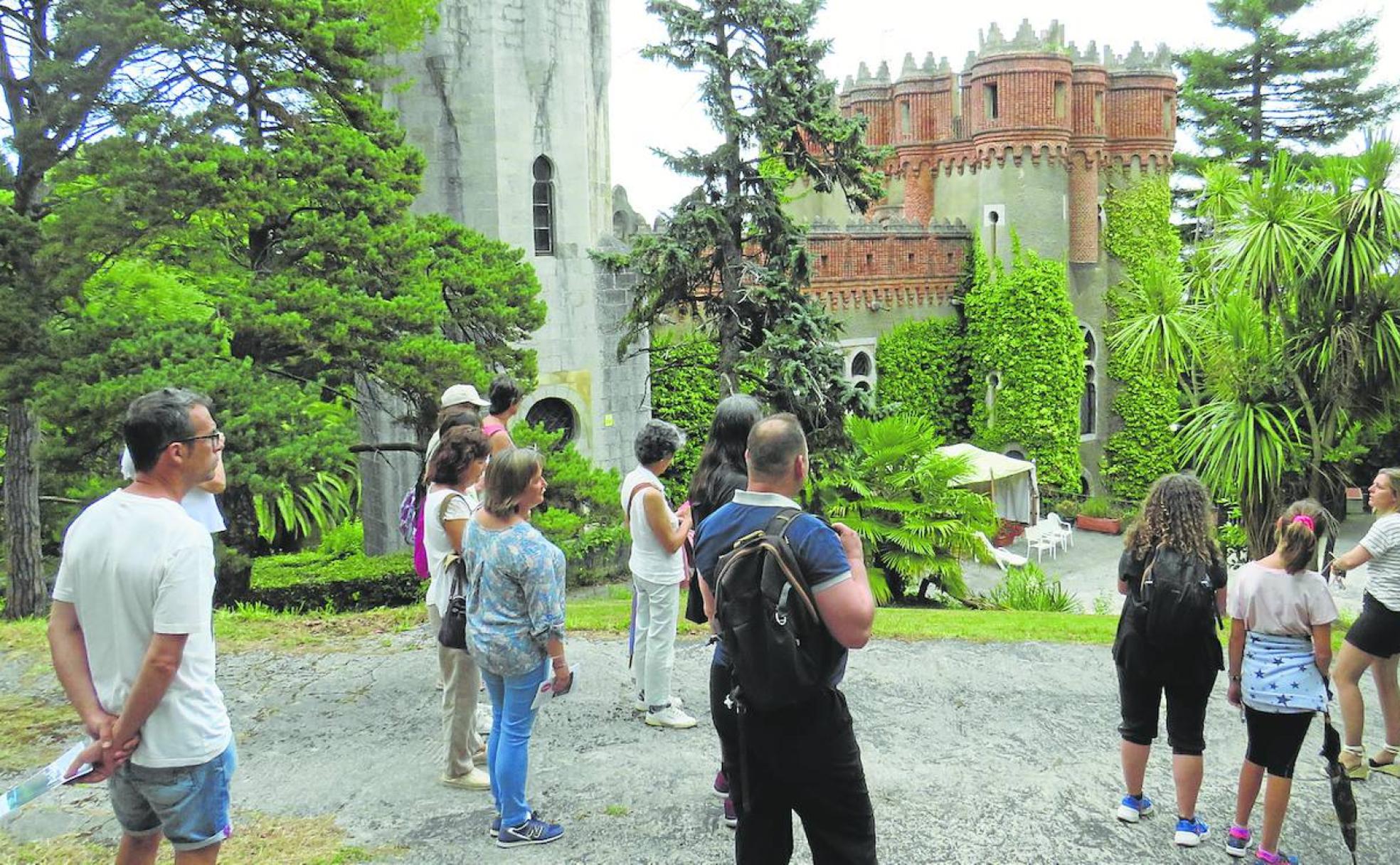 Un grupo de visitantes, en los jardines del castillo.