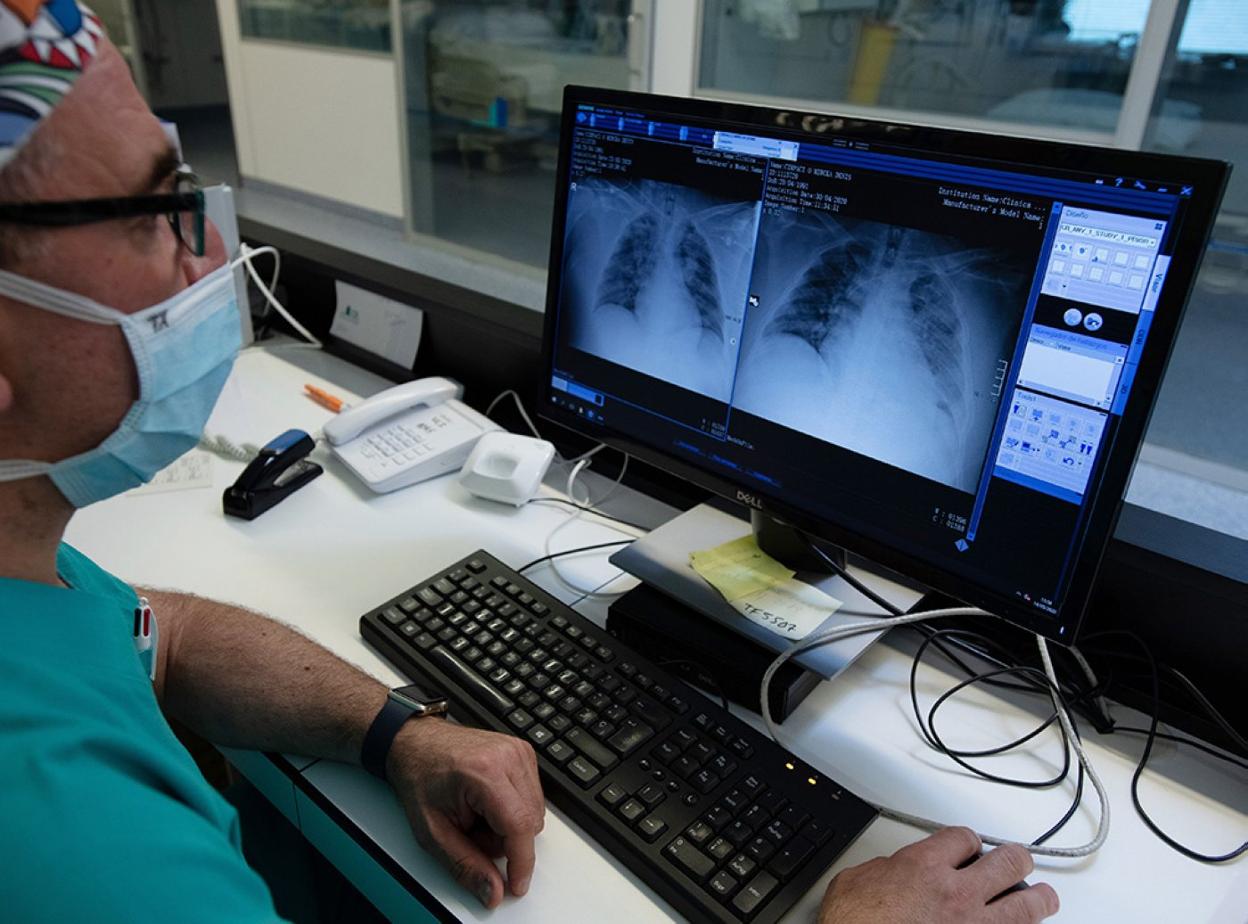 Un médico especialista supervisa en el ordenador las pruebas realizadas a un paciente.