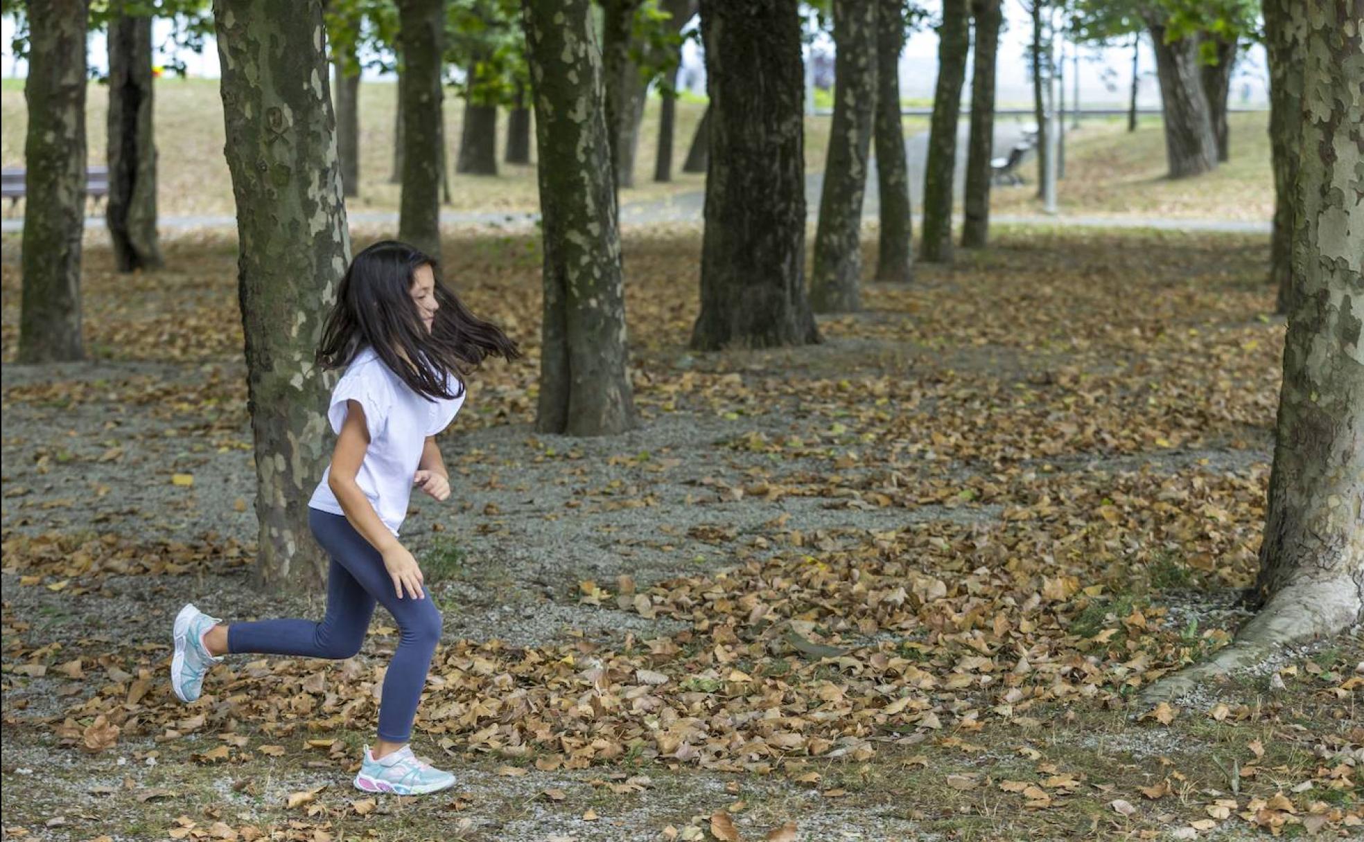 Una niña juega esta semana entre la multitud de hojas caídas de los plataneros que hay en el parque de Nueva Montaña en Santander. 