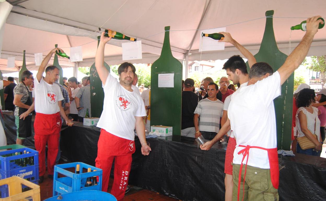 Integrantes de la Asociación Pomológica de Escalante escanciando sidra en la fiesta esta mañana.