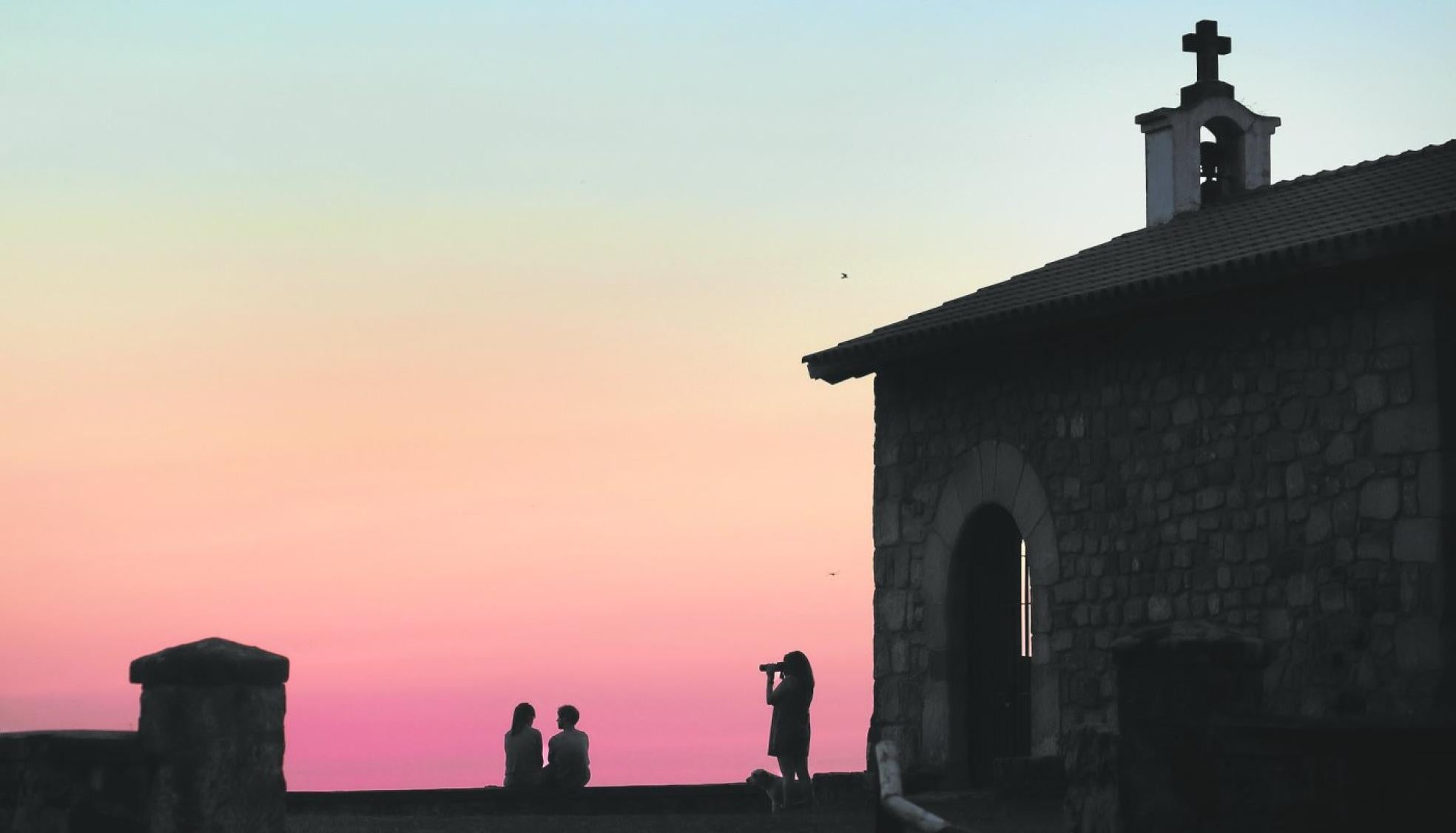 Tres jóvenes observan el atardecer desde el mirador de San Esteban, en pleno Monte Corona. 