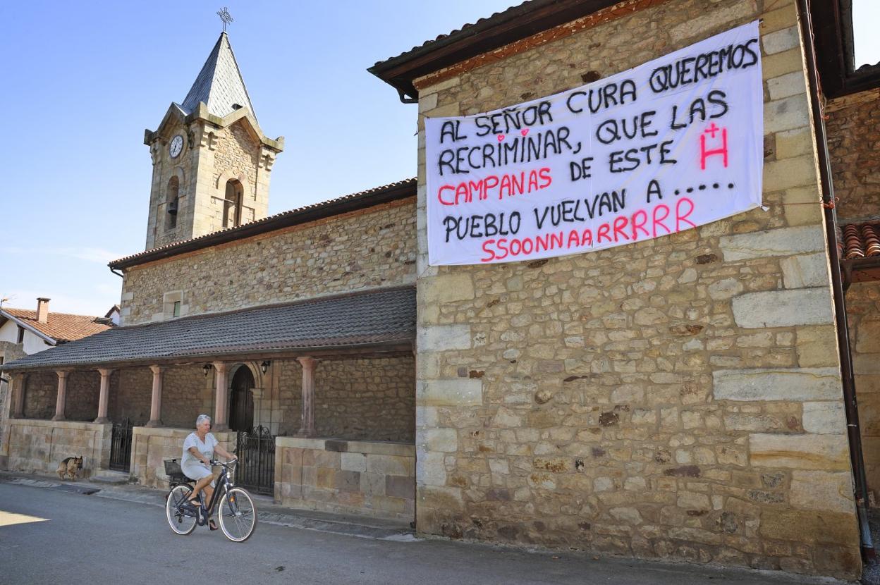 Pancarta que coloraron algunos vecinos en la iglesia en protesta por la decisión inicial del párroco. javier rosendo