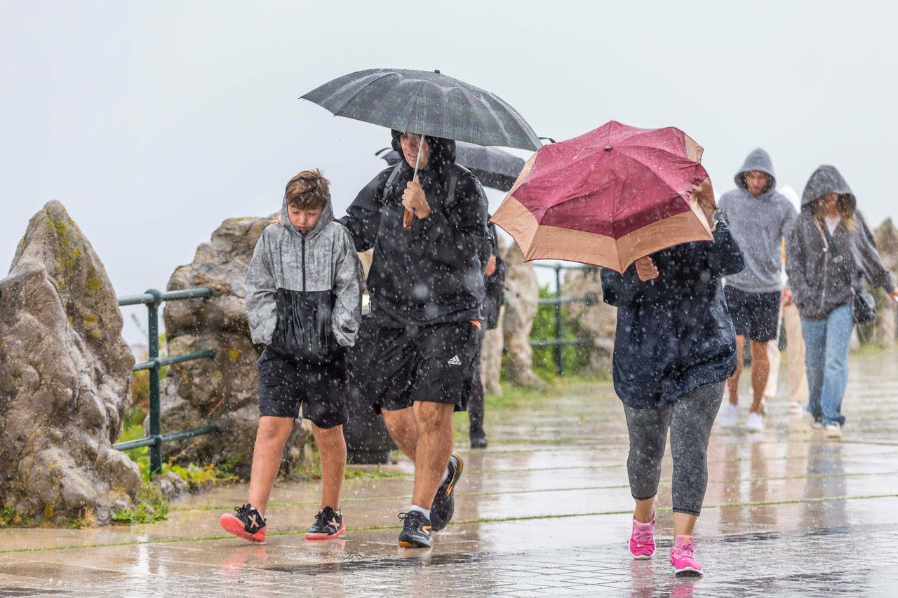 Fotos: Viandante bajo la lluvia en Santander, este miércoles