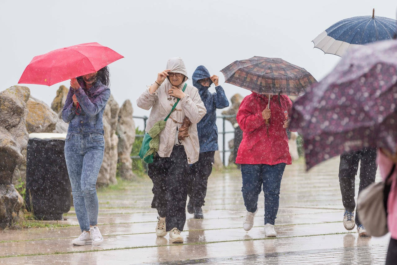 Fotos: Viandante bajo la lluvia en Santander, este miércoles