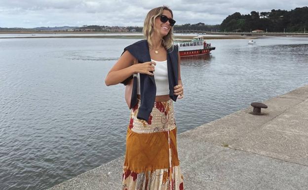 La 'influencer' apuesta por la falda larga de estilo 'boho' y 'top' blanco junto a una sudadera azul marino. 