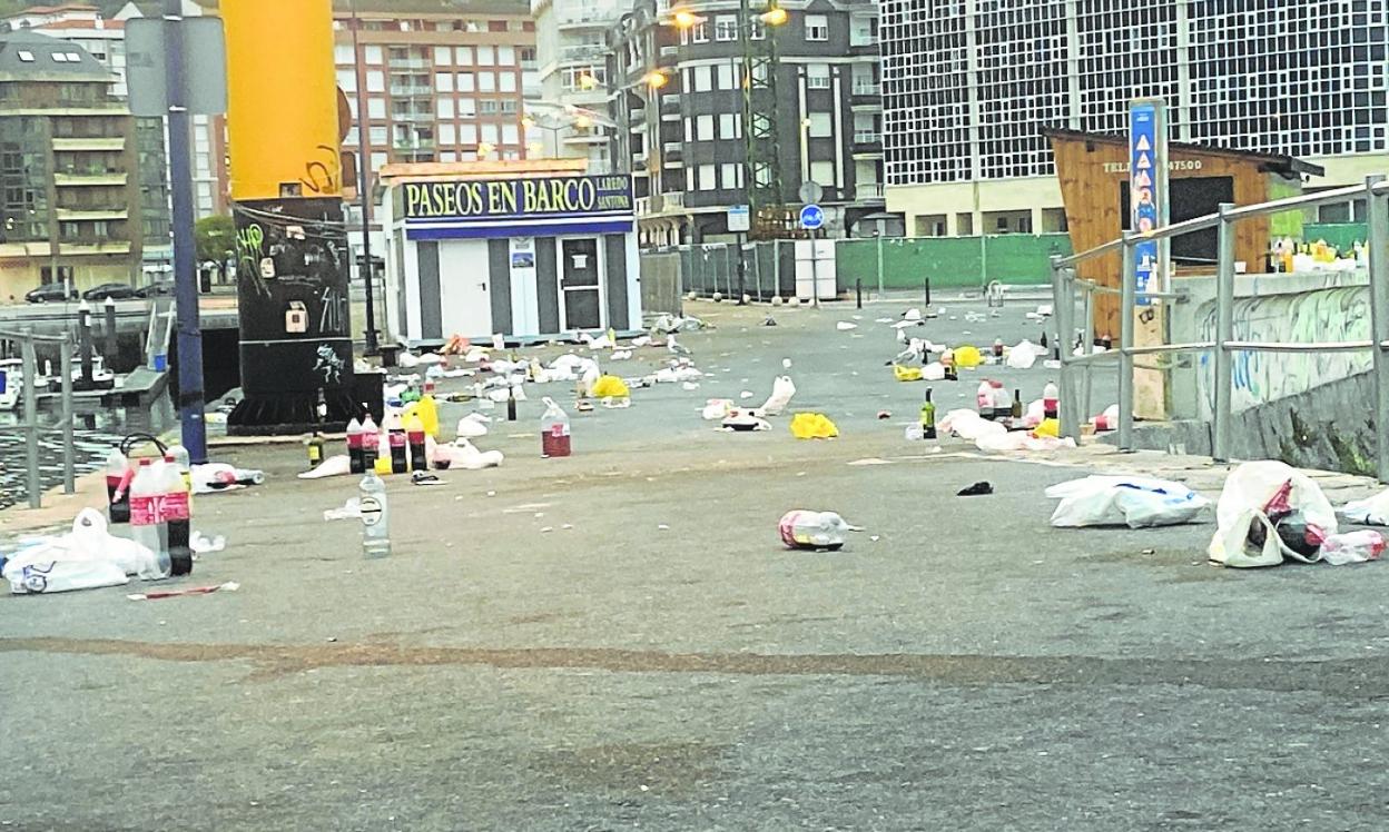 La zona del Caballito aparece alfombrada de cristales, bolsas y envases de plástico tras cada botellón. 