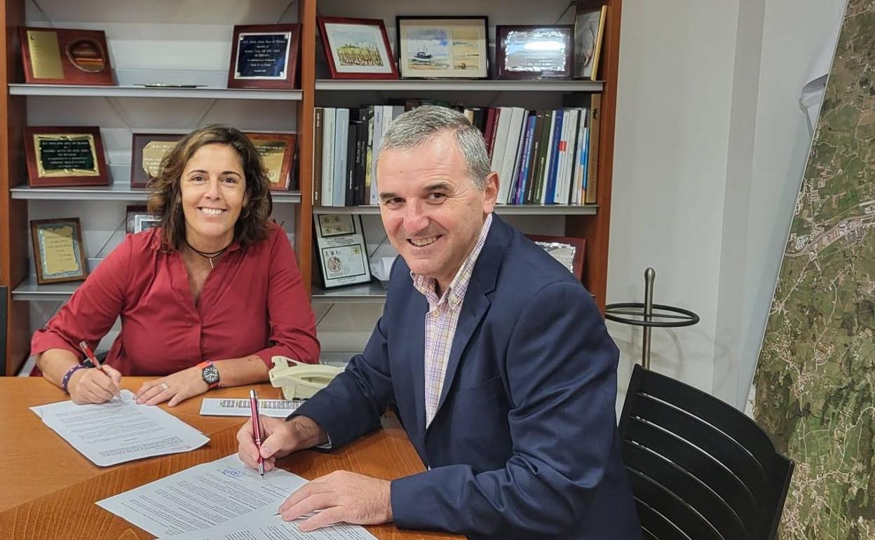 La gerente de la Fundación del Metal, Carmen de la Torriente, y el alcalde de Santa Cruz de Bezana, Alberto García Onandía, durante la firma del convenio de colaboración.