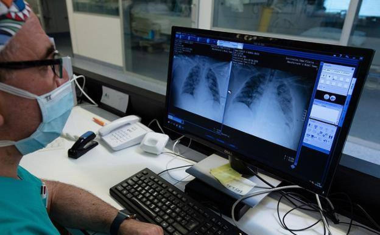 Un médico especialista supervisa en el ordenador las pruebas realizadas a un paciente.