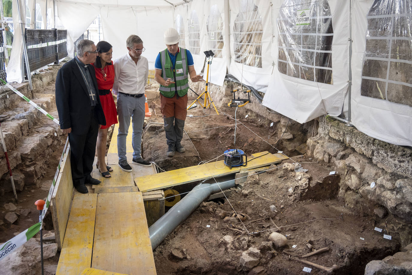 Manuel Sánchez Monge, Gema Igual y César Díaz escuchan las explicaciones de uno de los arqueólogos de la excavación.