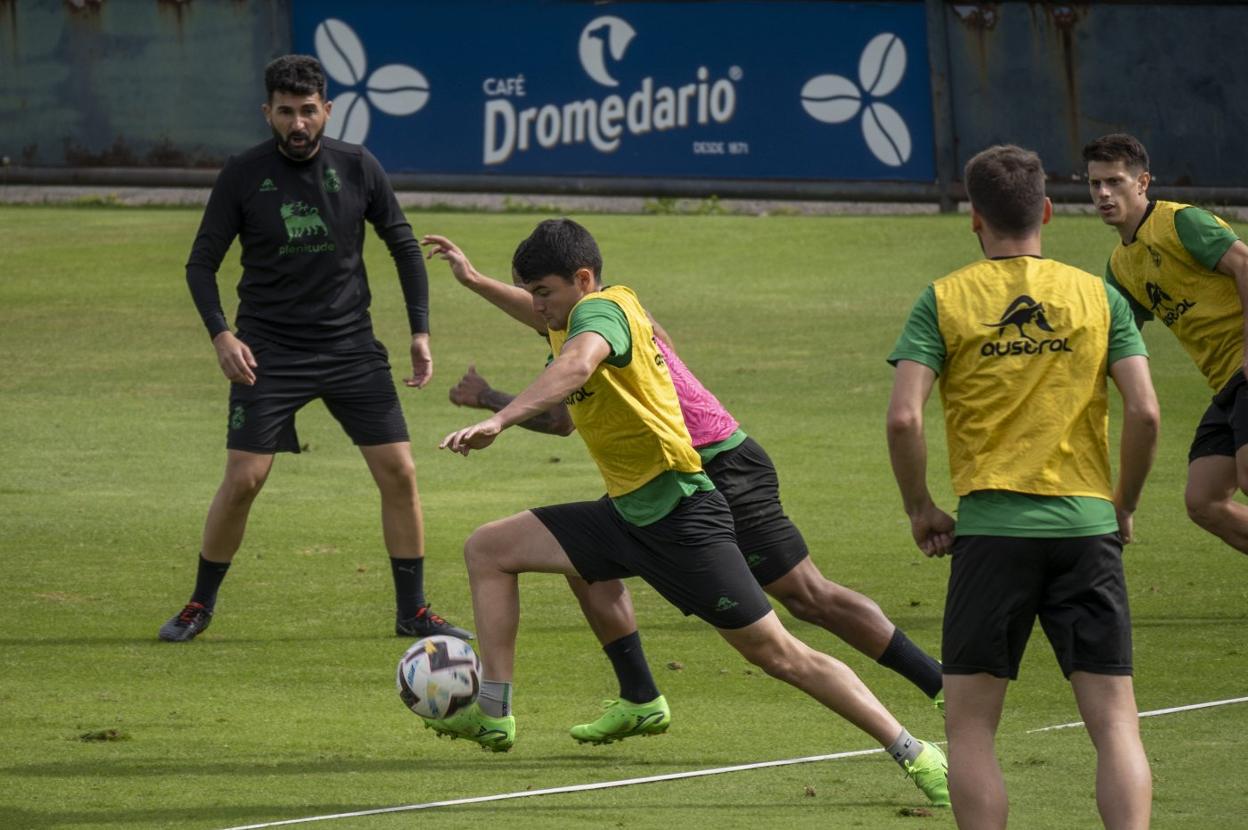 Guille Romo observa y anima a sus jugadores en un entrenamiento en La Albericia. A la derecha, Aritz Aldasoro esprinta en primer término con un compañero. 