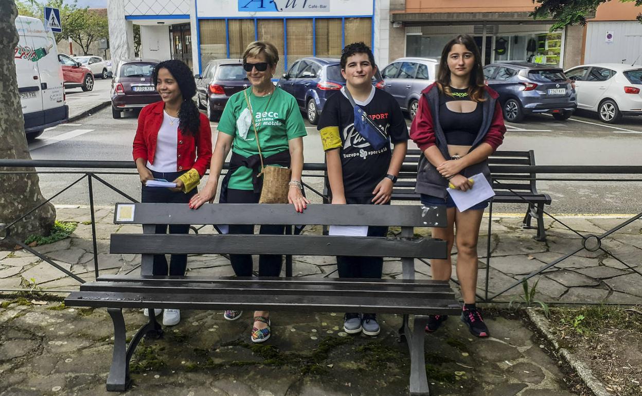 Algunos de los autores del proyecto, junto a la presidenta de la junta local de la AECC, Pilar Saiz Aguayo, en 'su' banco. 