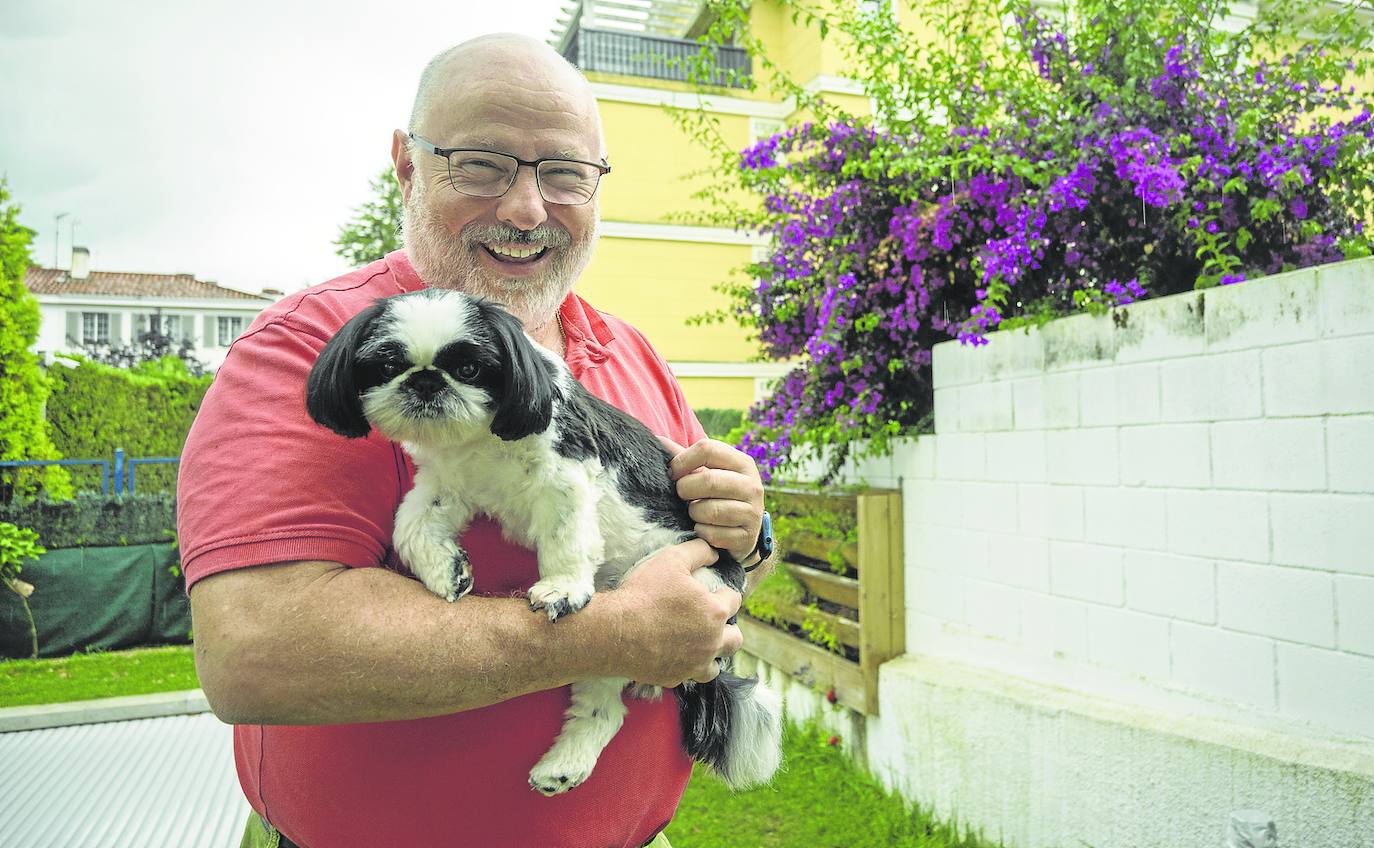 El economista Antonio Lamadrid y Queen, la reina de su casa, posan juntos en su jardín. 