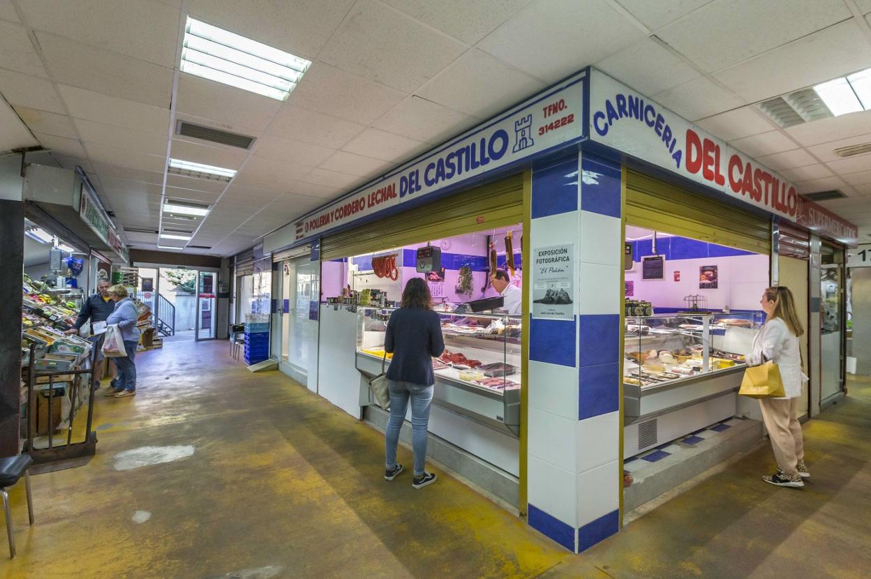 Comerciantes del Mercado de Puertochico, en Santander, ayer, atienden en sus puestos provisionales a varias clientas. 