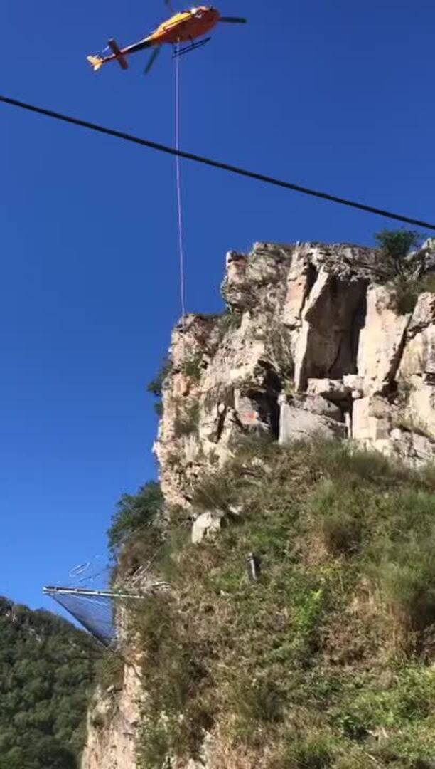 Un helicóptero derriba rocas para arreglar la carretera de Polaciones
